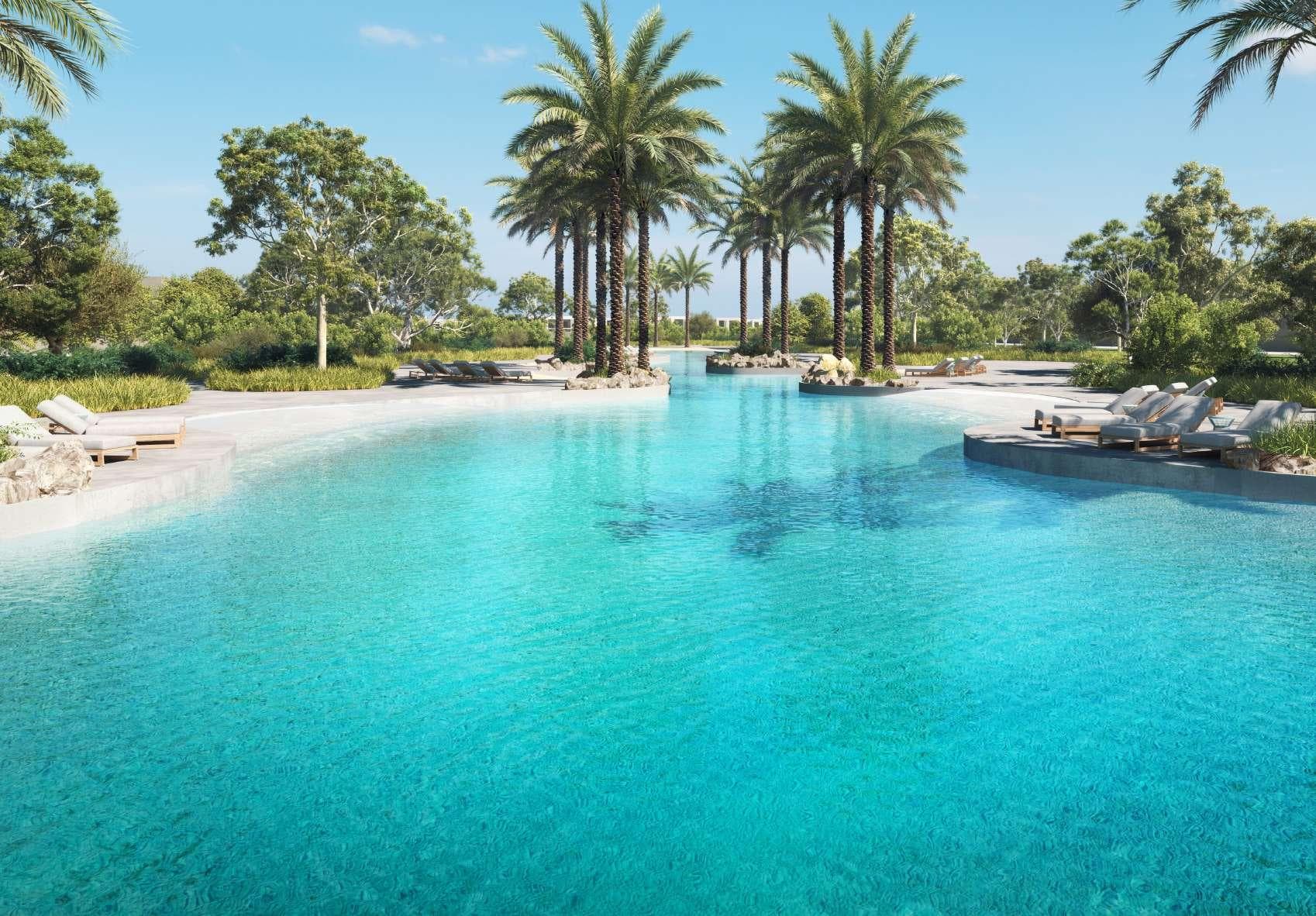 Hayyan's crystal-clear swimmable lagoon surrounded by palm trees and resort-style landscaping
